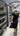 CEO standing inside a mining facility, wearing a OneMiners shirt, looking at equipment in a room with rows of miners and cables.