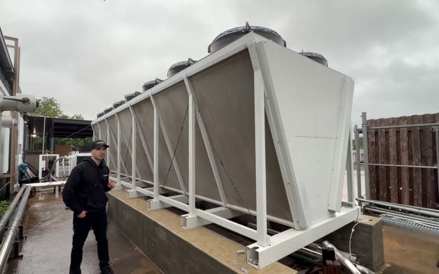 V-shaped dry cooler on a concrete plinth outside the Houston building