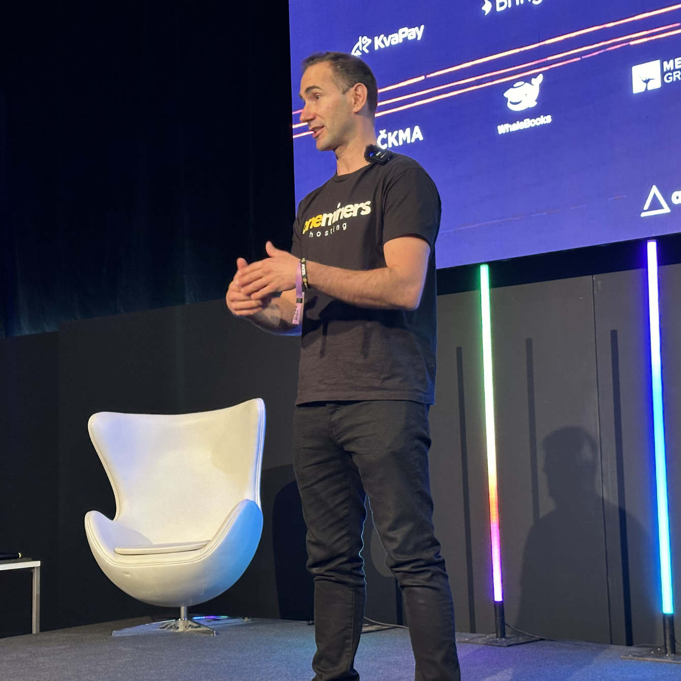 CEO of OneMiners speaking on stage at a conference.