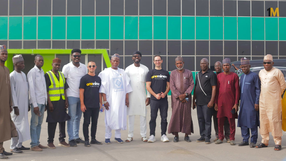 Group of people posing for a photo in front of a building with green and gray tiles.