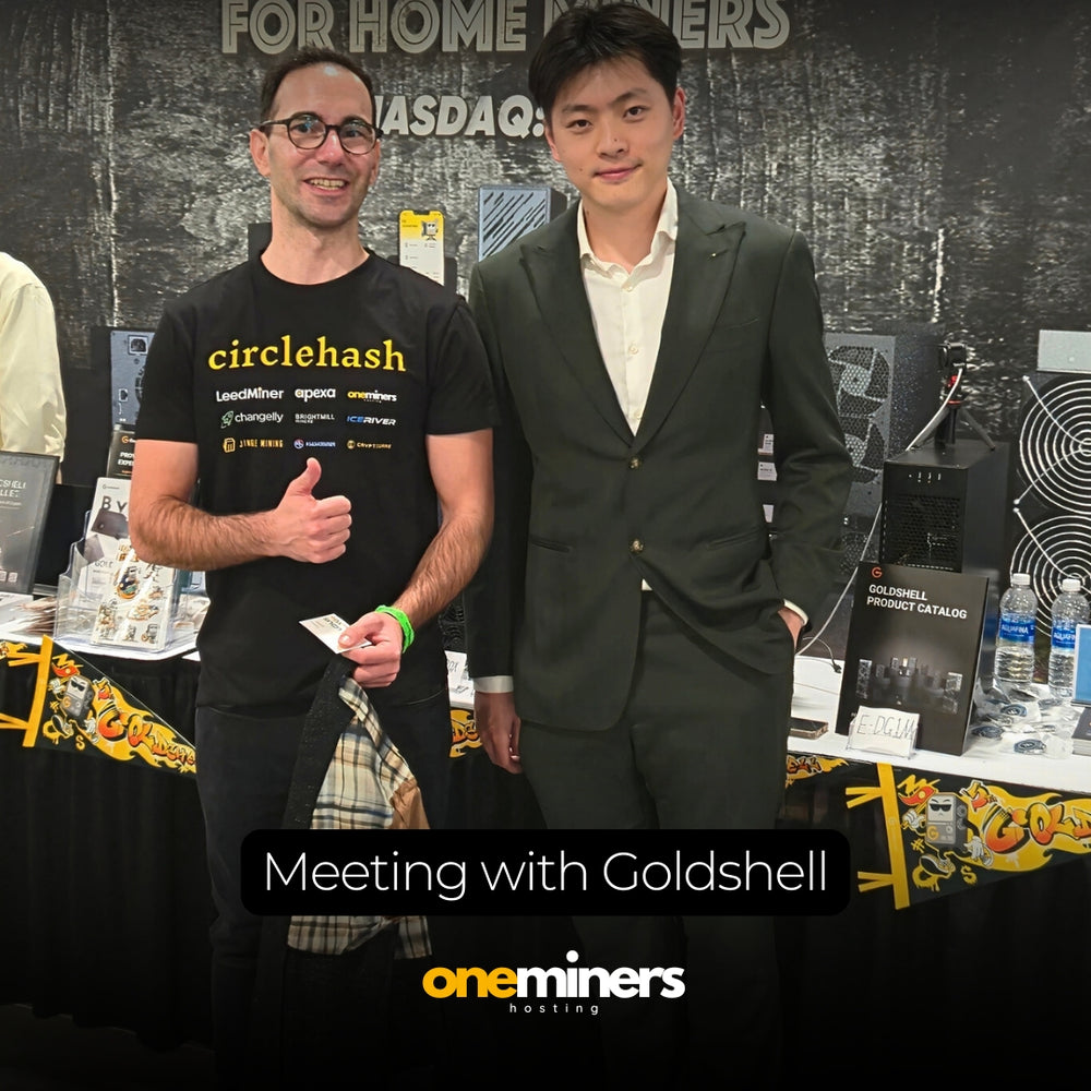 OneMiners team with Goldshell partner at event, smiling and shaking hands.